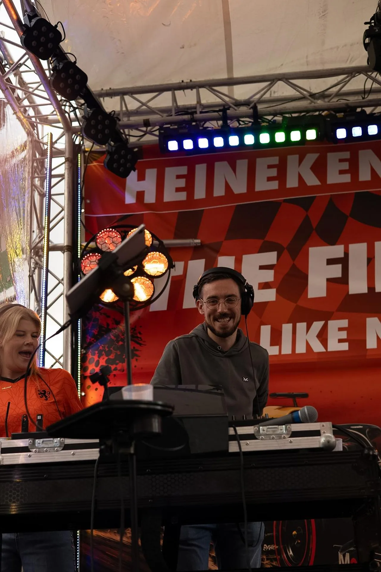 Barry lachend in een grijze hoodie bij de DJ-booth